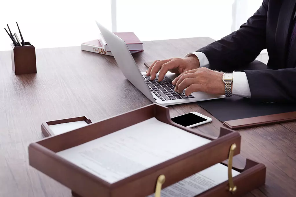 Male lawyer working with laptop in office, close up view